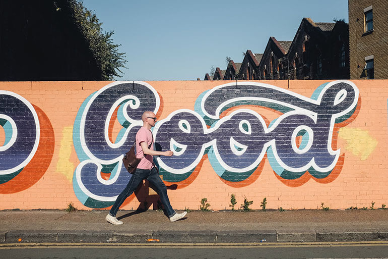 Man Walking Beside Graffiti Wall