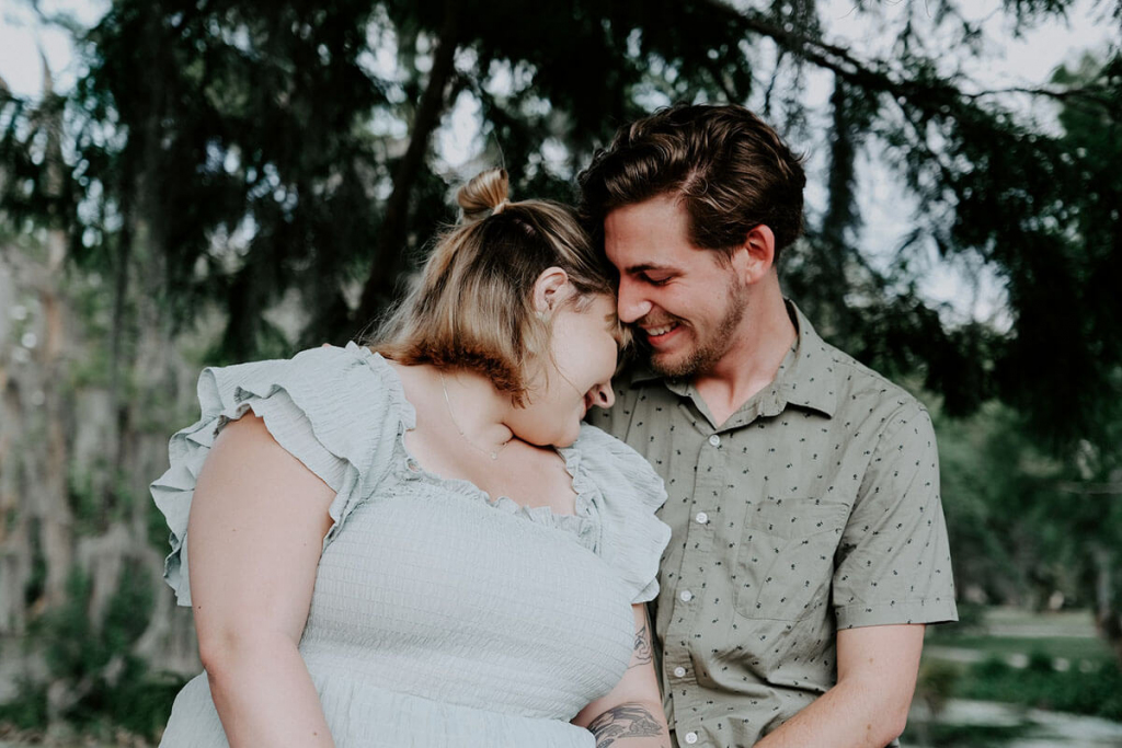 Man in Gray Shirt Kissing Plus Size Woman in White Dress